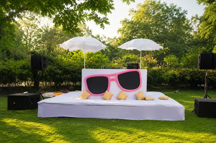 Outdoor sangeet stage with playful décor and speakers