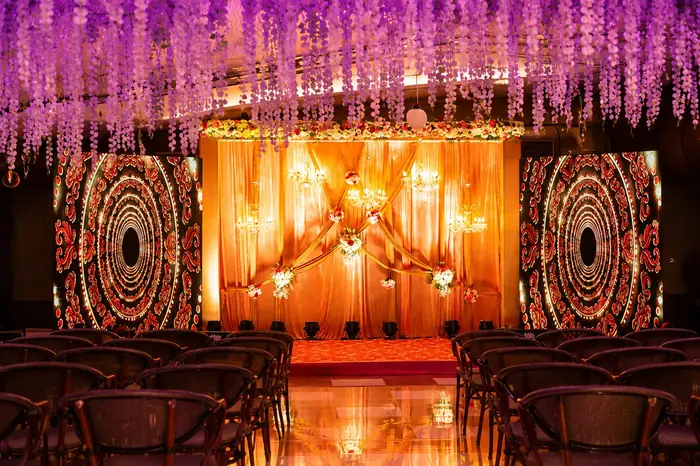 Grand indoor wedding stage with chandeliers and drapes